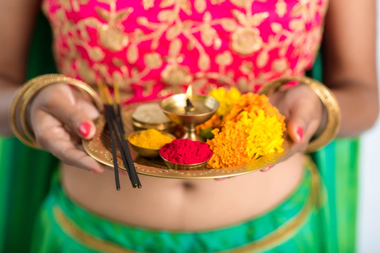Beautiful Indian young girl holding pooja thali or performing wo